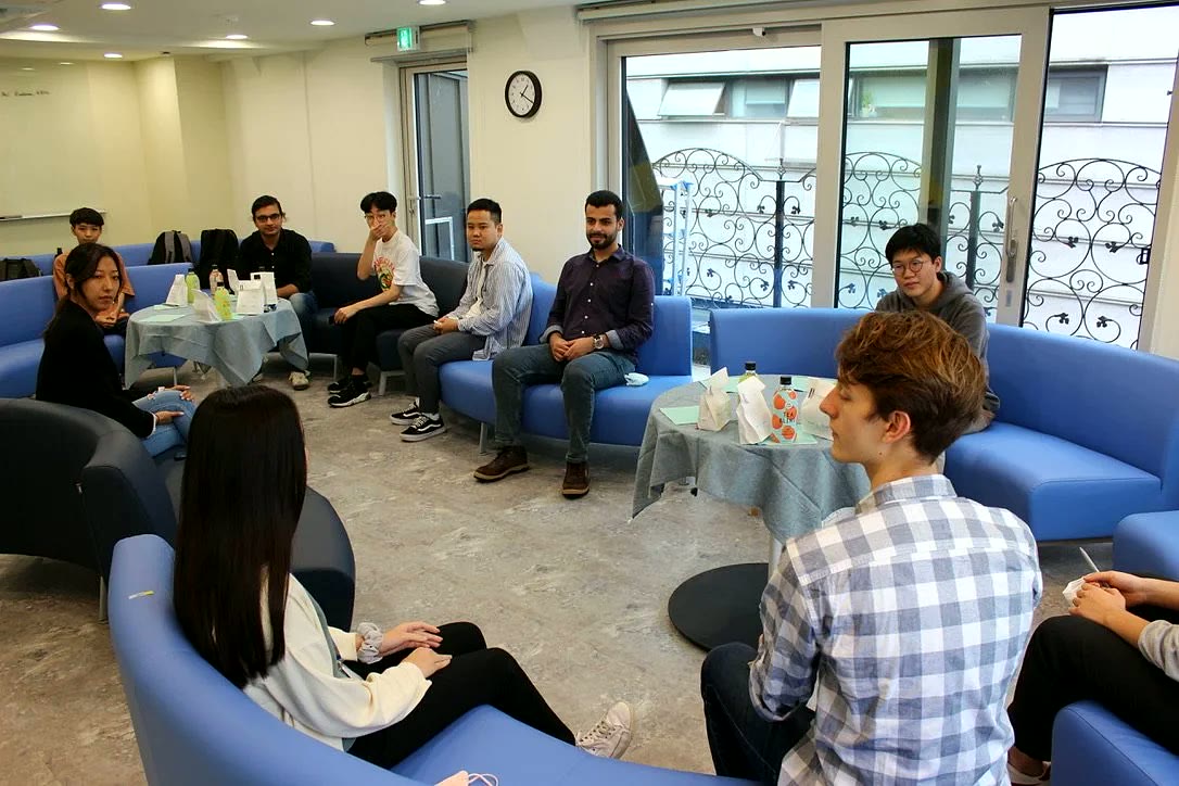 Brooks Douglass Scholars in a seminar discussion circle on blue lounge seating.