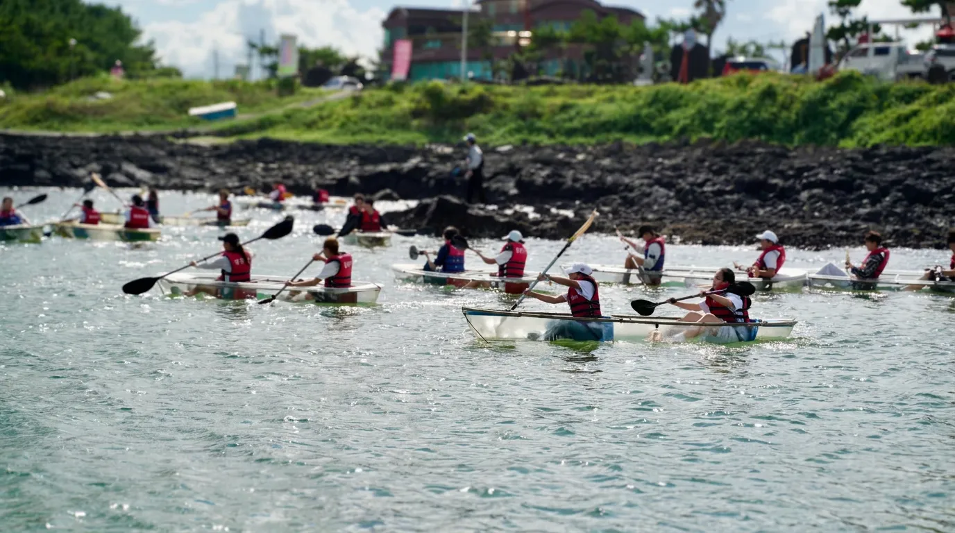 EOS students kayaking together on open water, with the distant shore softly blurred.
