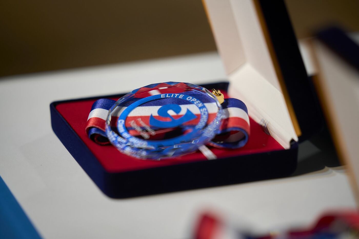An Elite Open School graduation medal in its presentation case